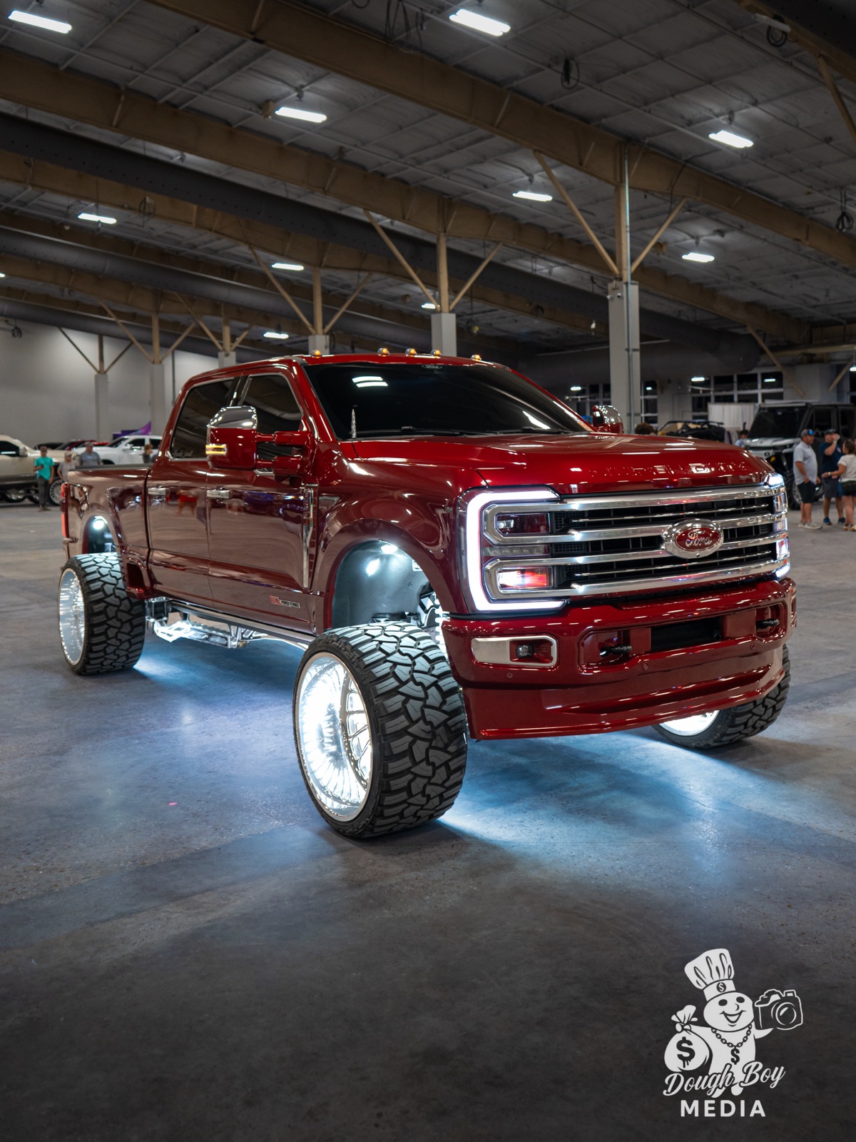 A custom lifted show truck glowing under the lights at the HardyCo Showdown
