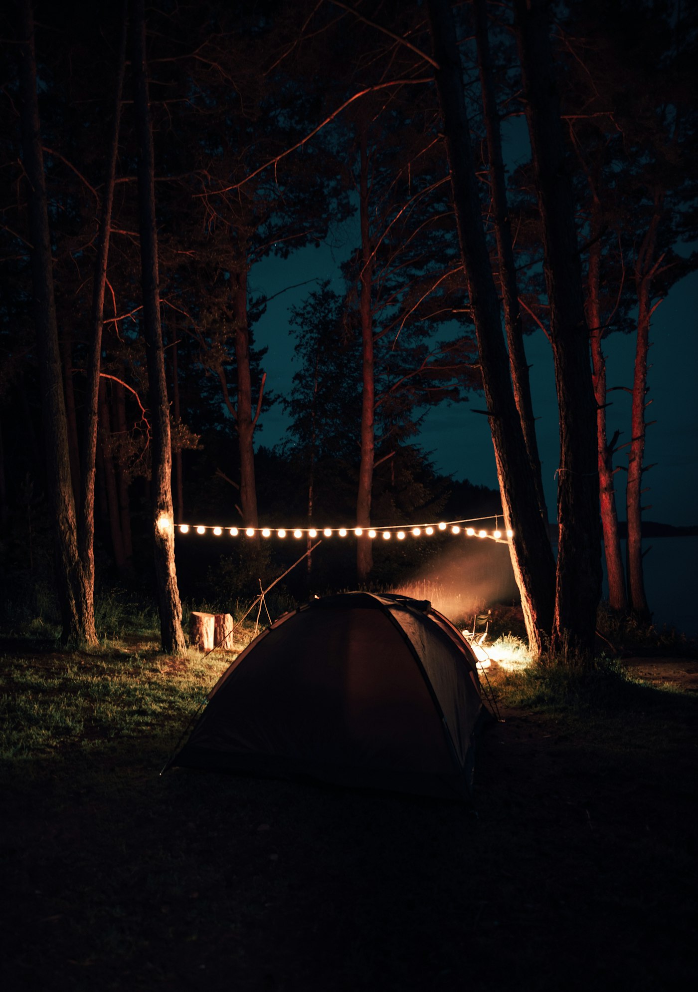 A tent lit up at a campsite at night